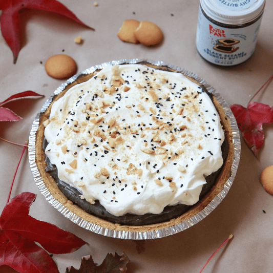 A homemade black sesame banana pudding pie surrounded by vanilla wafers and red maple leaves.