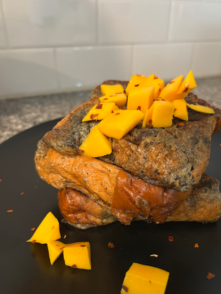 black sesame crunchy butter French toast topped with mango and chili flakes